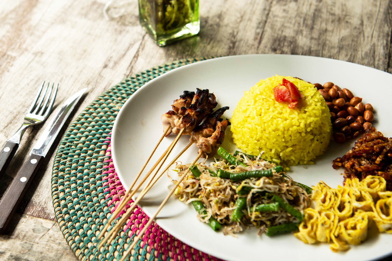 Yellow rice with satay, long beans, peanuts and omelette
